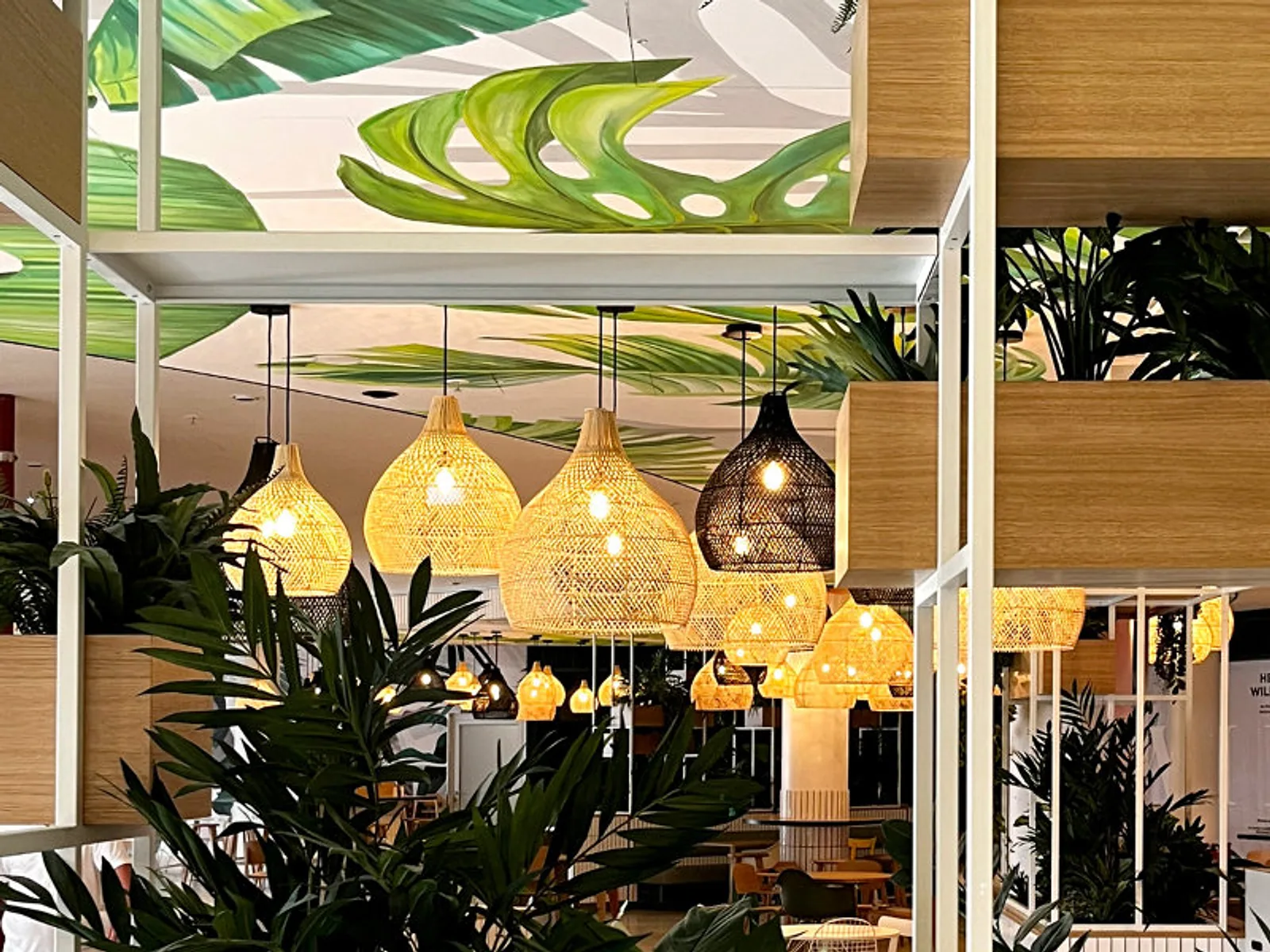 Foodcourt der Dreiländergalerie in Weil am Rhein mit Rattanleuchten, Pflanzeninseln und Sitzbänken aus FSL-Fertigung